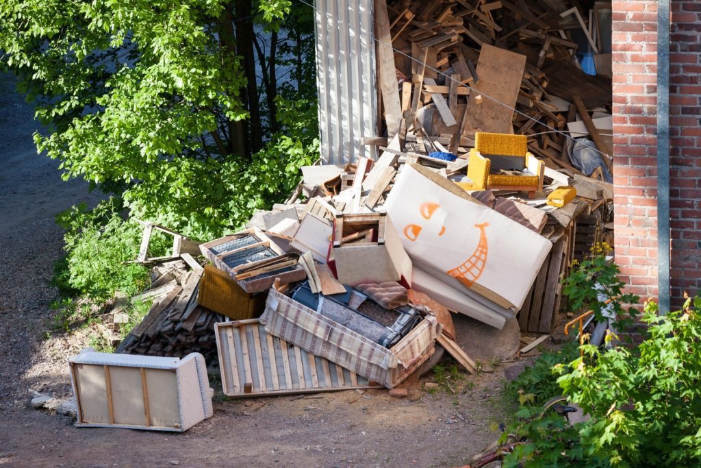 Pile of old furniture and construction debris outside a building before junk removal services in Delaware County