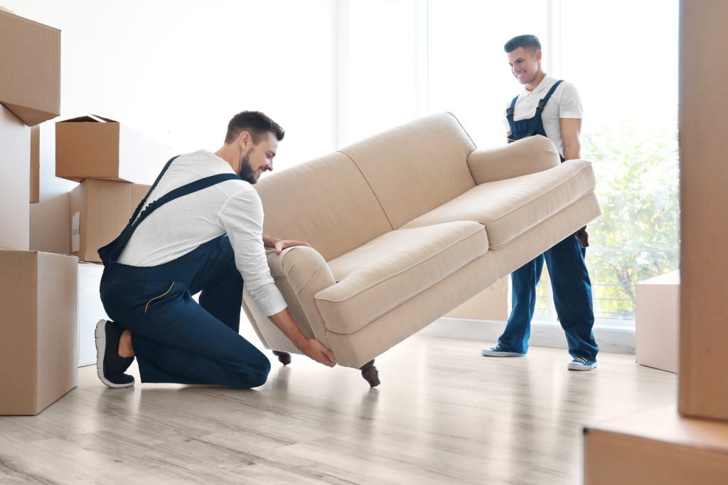 Two professional movers lifting a sofa during a residential move in Delaware County