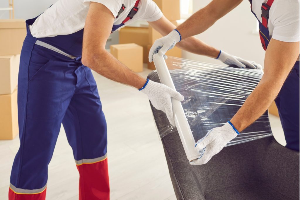 Professional movers wrapping a chair with protective plastic for safe transport during a move in Delaware County