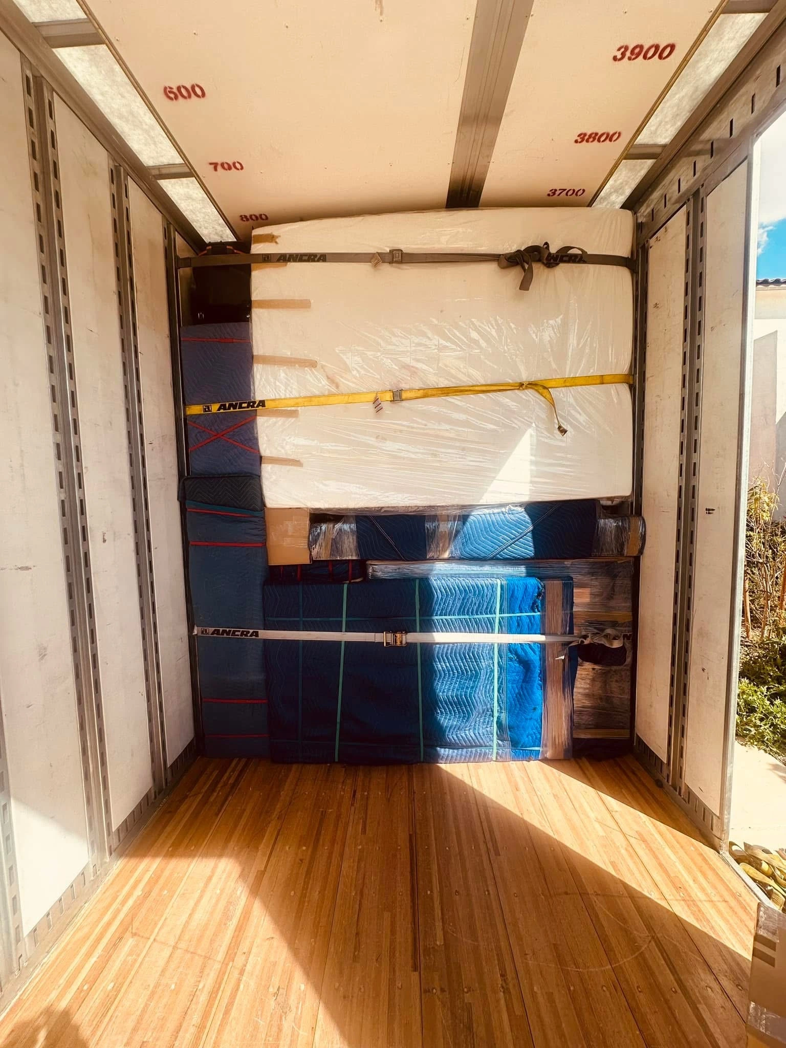 Best local moving company securing mattress and furniture inside moving truck