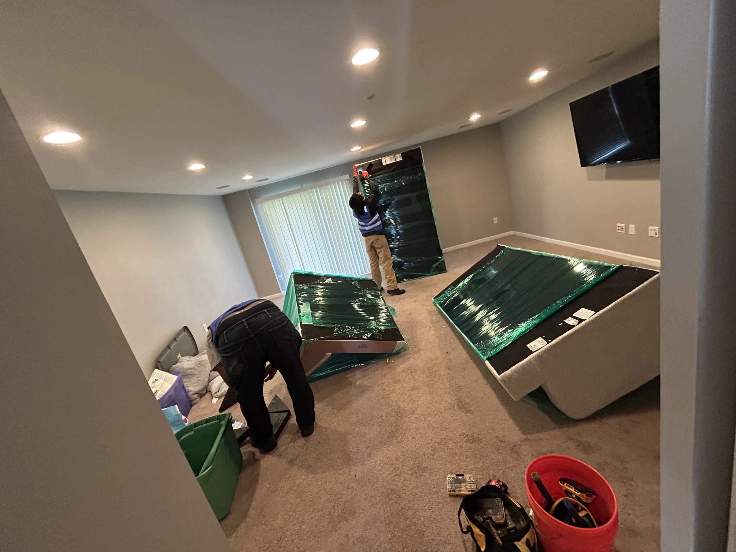 Movers wrapping and disassembling furniture inside home