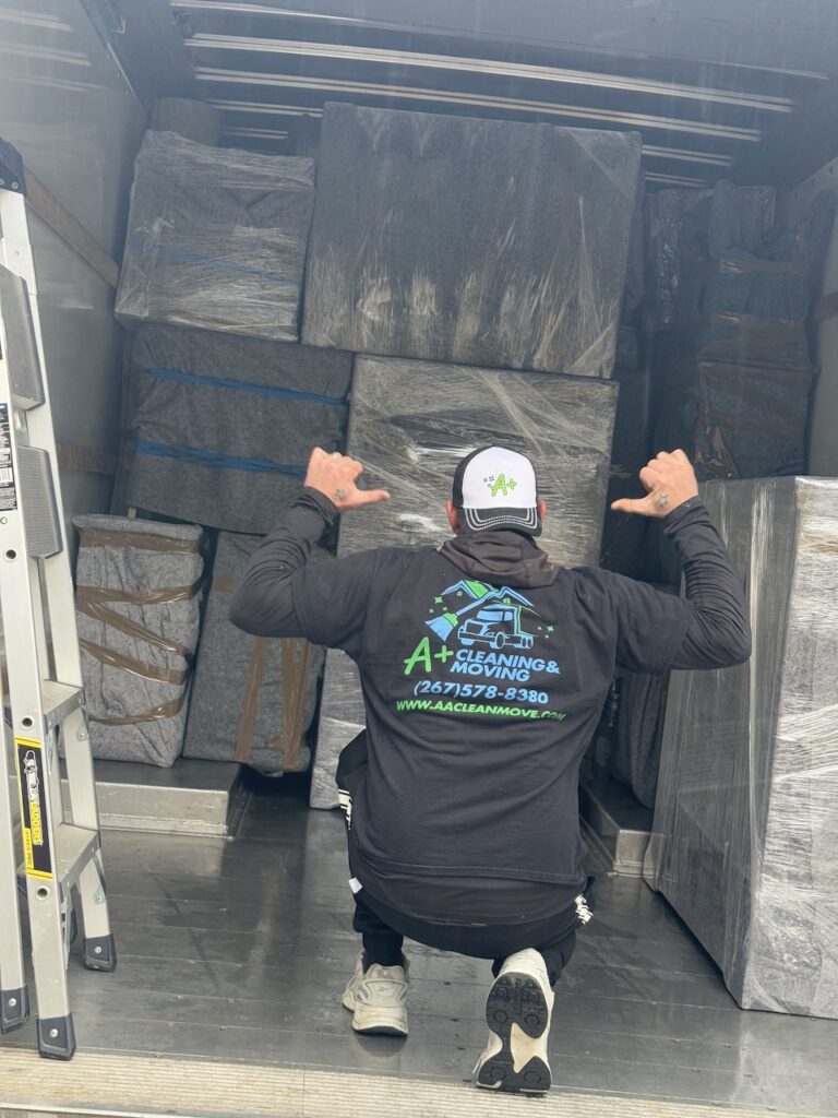 Professional Chester County movers loading wrapped furniture into a moving truck during a residential relocation